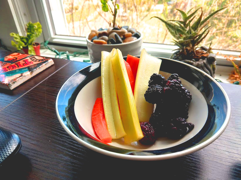 Celery, carrots, and blackberries in a bowl