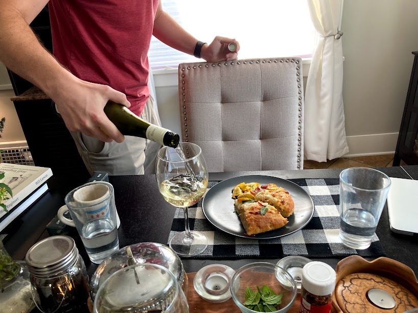 Man pours white wine at the dinner table